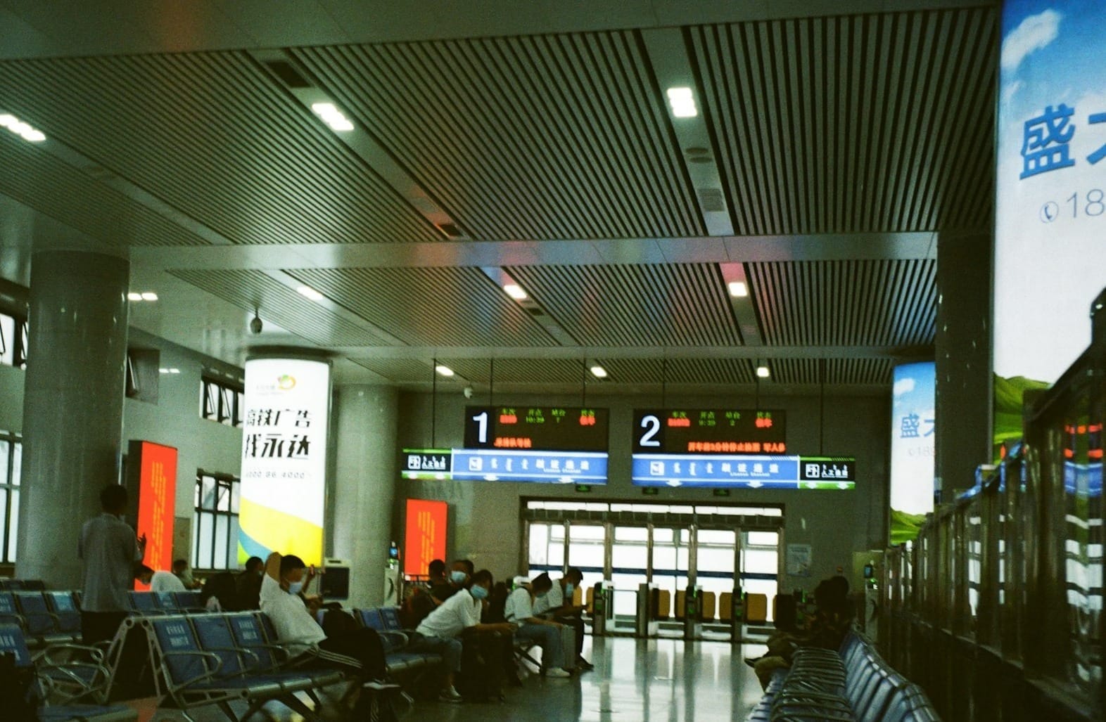 a group of people sitting in a large room with a large screen